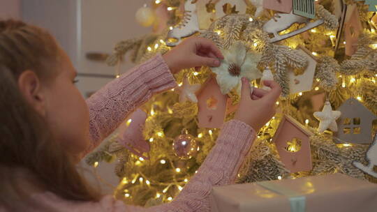 小女孩在家用装饰品装饰圣诞树
