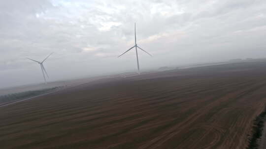 风力涡轮机能源生产的高动态Fpv无人机视图，雾蒙蒙的早晨4k空中拍摄