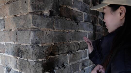 中国女性站在烽火台里观察墙壁文字