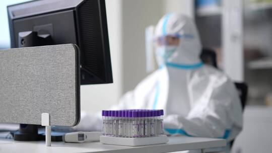 实验室防护服护目镜科研人员比对着试管工作