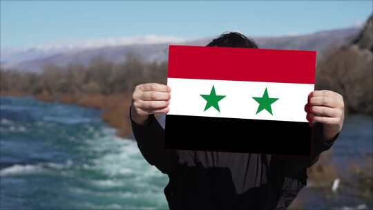 手持叙利亚国旗旗帜的人