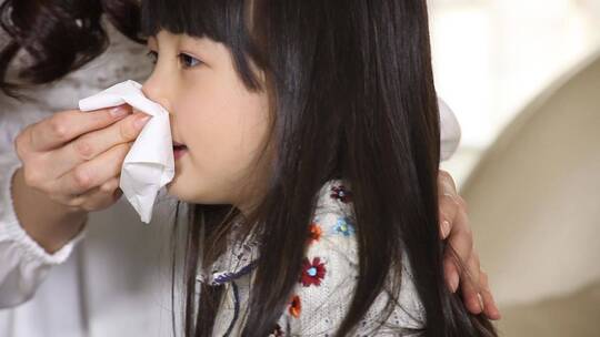 年轻的妈妈帮女儿擦鼻子秋季干噪儿童流鼻血