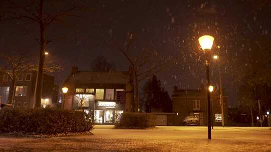 夜晚大雪下的街道路灯