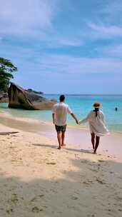 一对男女在泰国南部热带岛屿斯米兰的海滩上放松