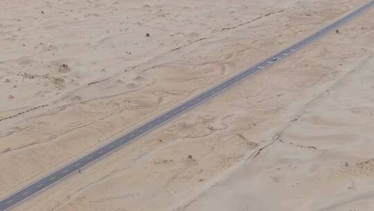 航拍汽车行驶在新疆塔克拉玛干沙漠公路上