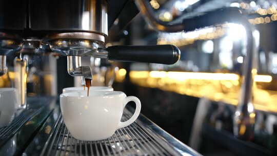 餐厅的专用咖啡机将咖啡倒入杯子
