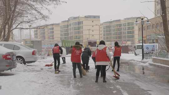 志愿者在马路上铲雪视频素材模板下载