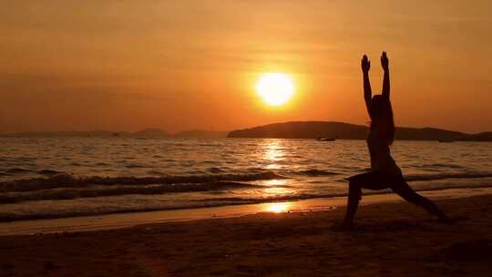 日落海滩边练瑜伽的女人