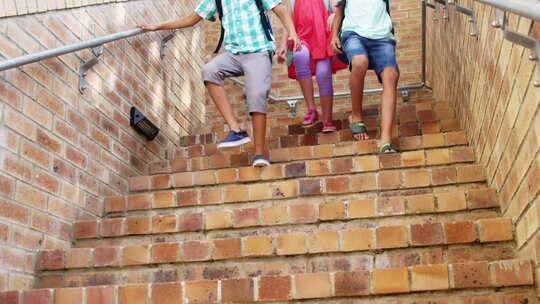 微笑的小学生走在学校的楼梯上