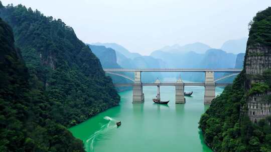 绿水青山间的大桥及江上小船景象