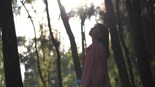 美女站在森林里感受自然的女孩融入自然环境