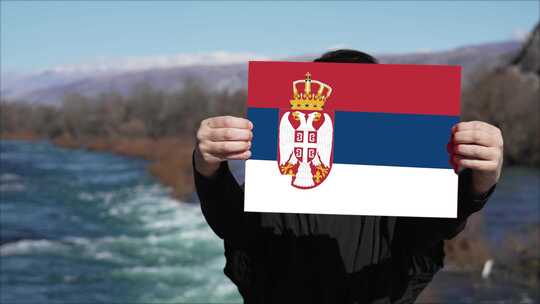 手持塞尔维亚国旗横幅的人