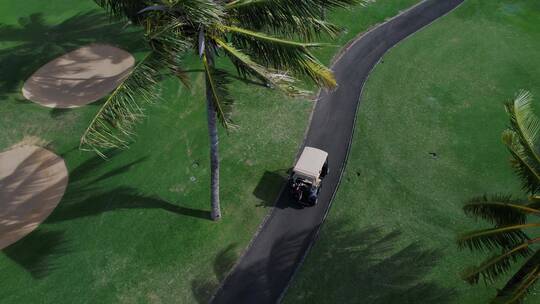 航拍高尔夫运动员驾驶高尔夫球车