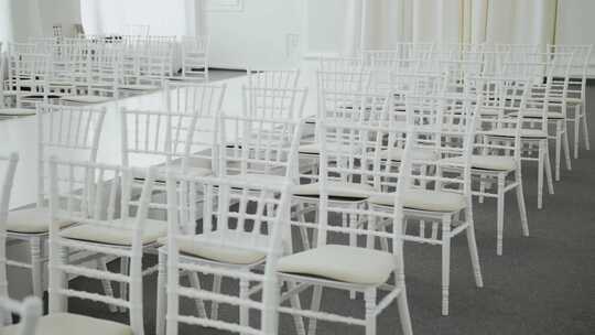 为客人准备了许多白色椅子白色婚礼大厅装饰