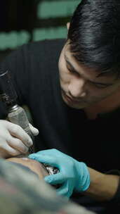 亚洲纹身艺术家在工作室创意概念中为客户纹