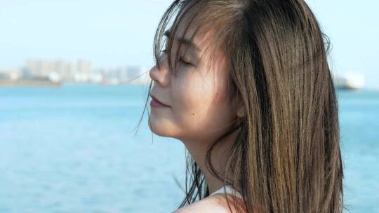 女孩在海边吹风感受阳光4k视频素材