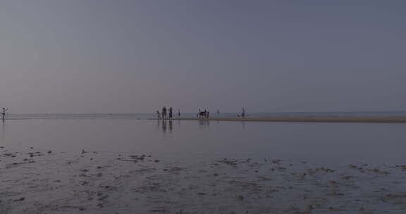 海南漫步在光村海滩的游客