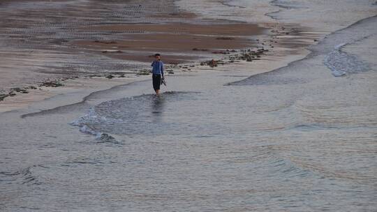 海边沙滩上溜达的一个人