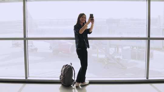 女孩用手机自拍 拍摄飞机和跑道