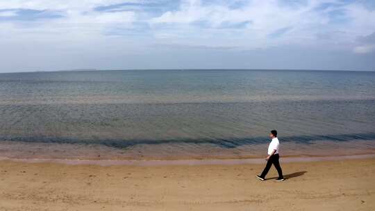 男子在海边沙滩上行走