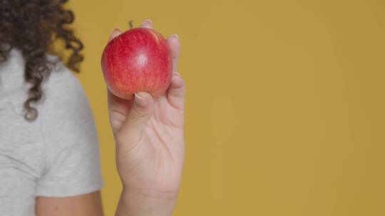 年轻成年女性手持苹果的特写镜头