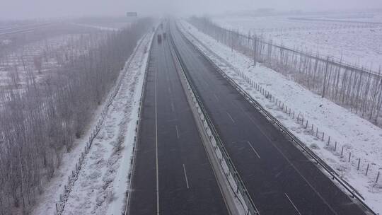 风雪中货运车队行驶在高速公路