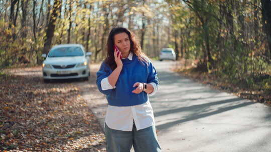 紧急电话让在路上处理汽车故障会谈的妇女心