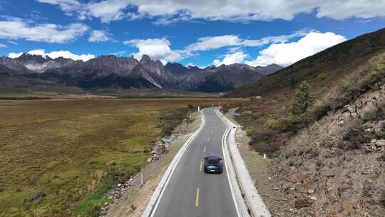 航拍汽车行驶在四川甘孜理塘措普沟户外道路