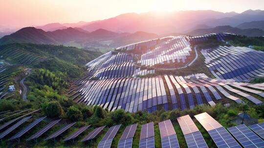 新能源太阳能光伏发电站夕阳下山坡航拍