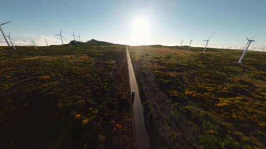 新能源汽车行驶 草原上的风力发电机俯拍