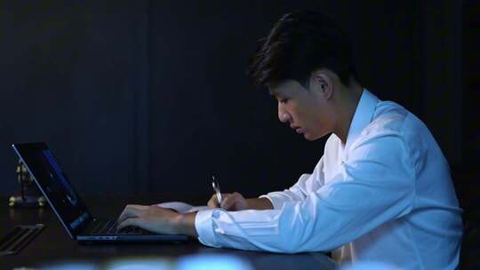 艰难创业男子夜晚加班写方案
