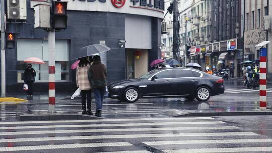 上海南京路下雨行人撑伞过马路斑马线红绿灯