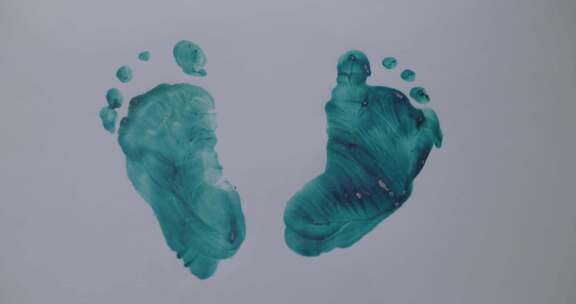 一丝不苟的人类脚印，在灰色表面用绿色油漆