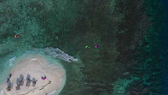风筝冲浪者在珊瑚礁上的沙岛上冲浪，坠入公