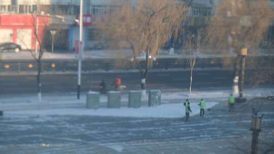 路边打扫积雪的环卫工人和路过的行人