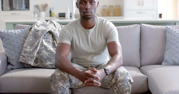 年轻的非裔美国士兵自信地坐在家里，有复印