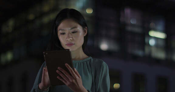 深思熟虑的亚洲女商人晚上在办公室使用平板电脑的视频