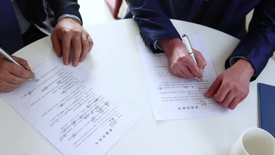 两个签署合同协议和整理文件的商人