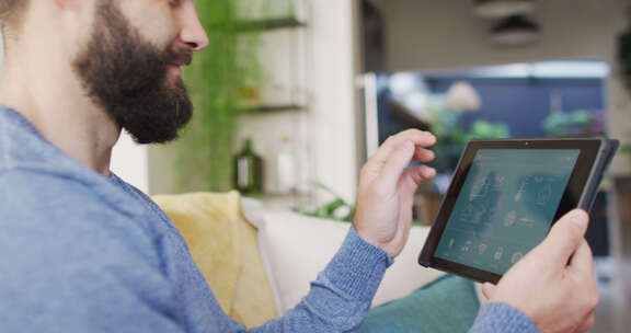 快乐的高加索男子在家中平板电脑上使用智能家居界面的视频