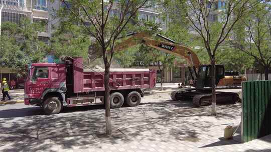 挖掘机揭去城区柏油路面装入渣土车视频素材模板下载