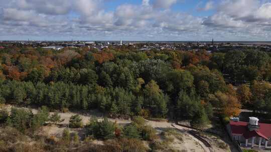 无人机正在飞越森林，飞向拉脱维亚城市景观欧洲