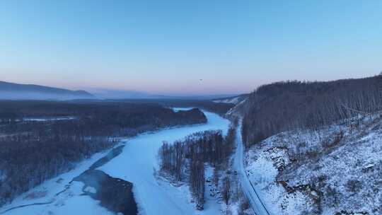 鸟瞰黎明时的林海雪原冰封河流