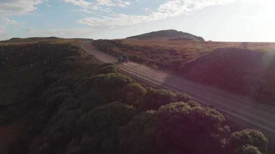 一架无人机跟踪一辆在土路上行驶的汽车