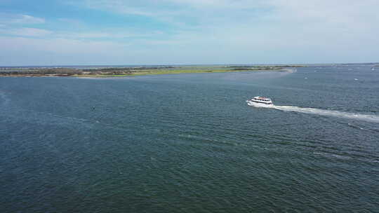在一个阳光明媚的日子里，一架无人驾驶飞机俯瞰琼斯湾。摄像机向一艘旅游船飞去