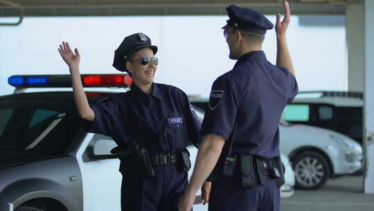 男女警务人员在停车场击掌交流