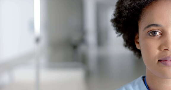 非裔美国护士在明亮的医院走廊上温暖地微笑
