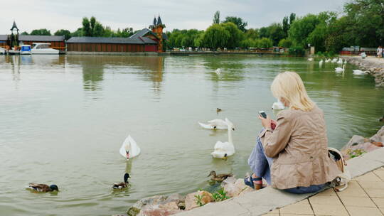 女子在水边使用智能手机