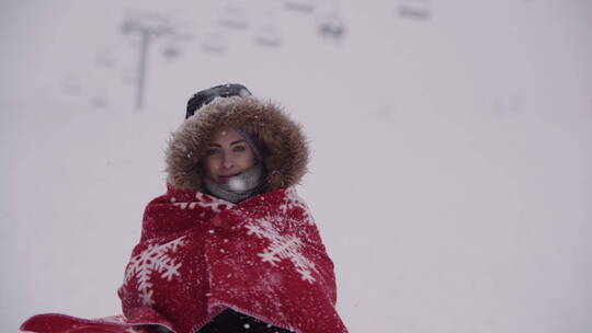 女人在雪中裹上毯子