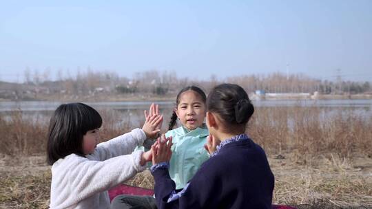 冬季在公园草坪上玩游戏的三个女孩