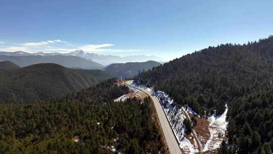 航拍雪山下的森林公路